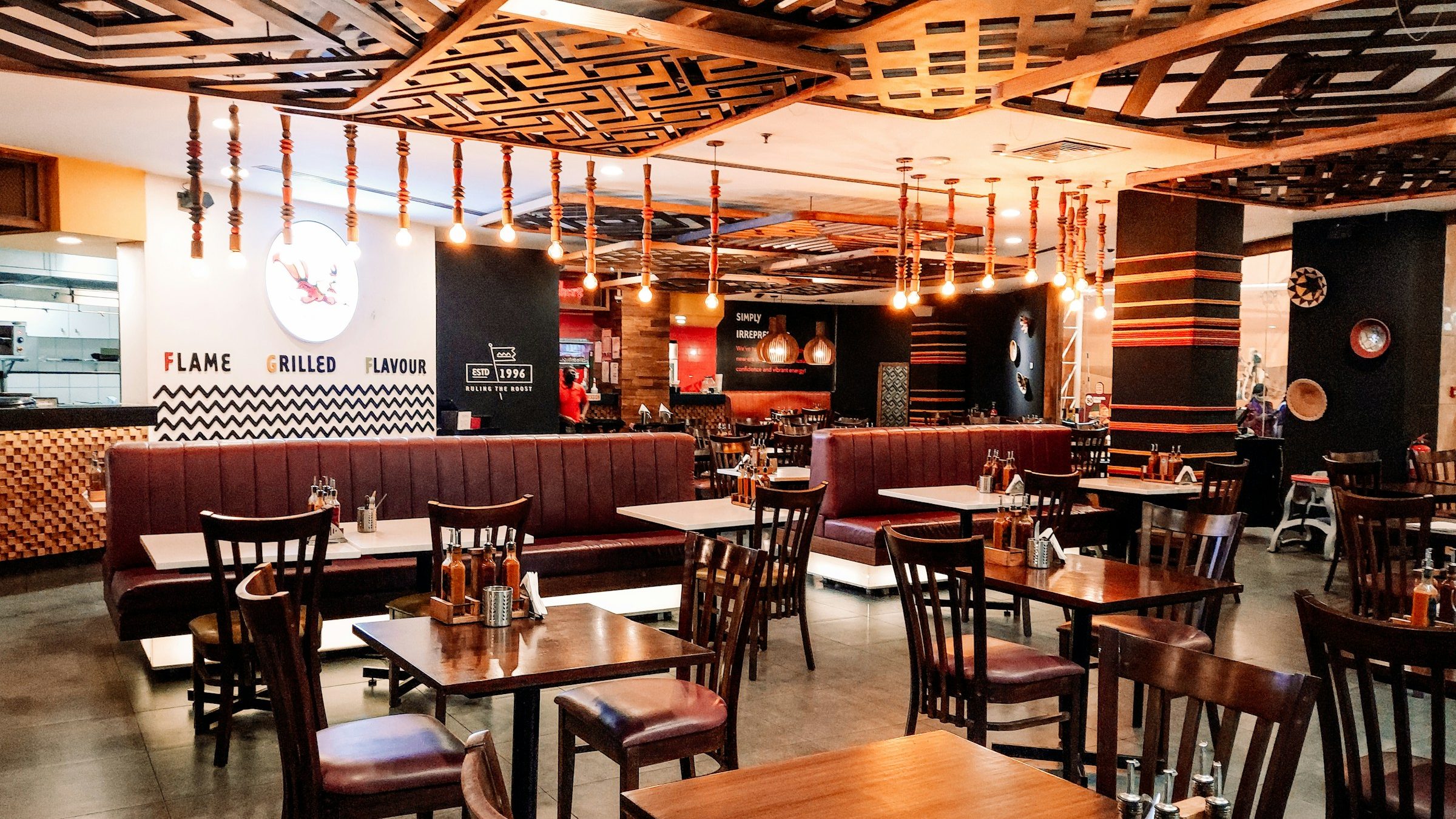 Grill restaurant with burgundy banquettes, dark timber tables and leather dining chairs