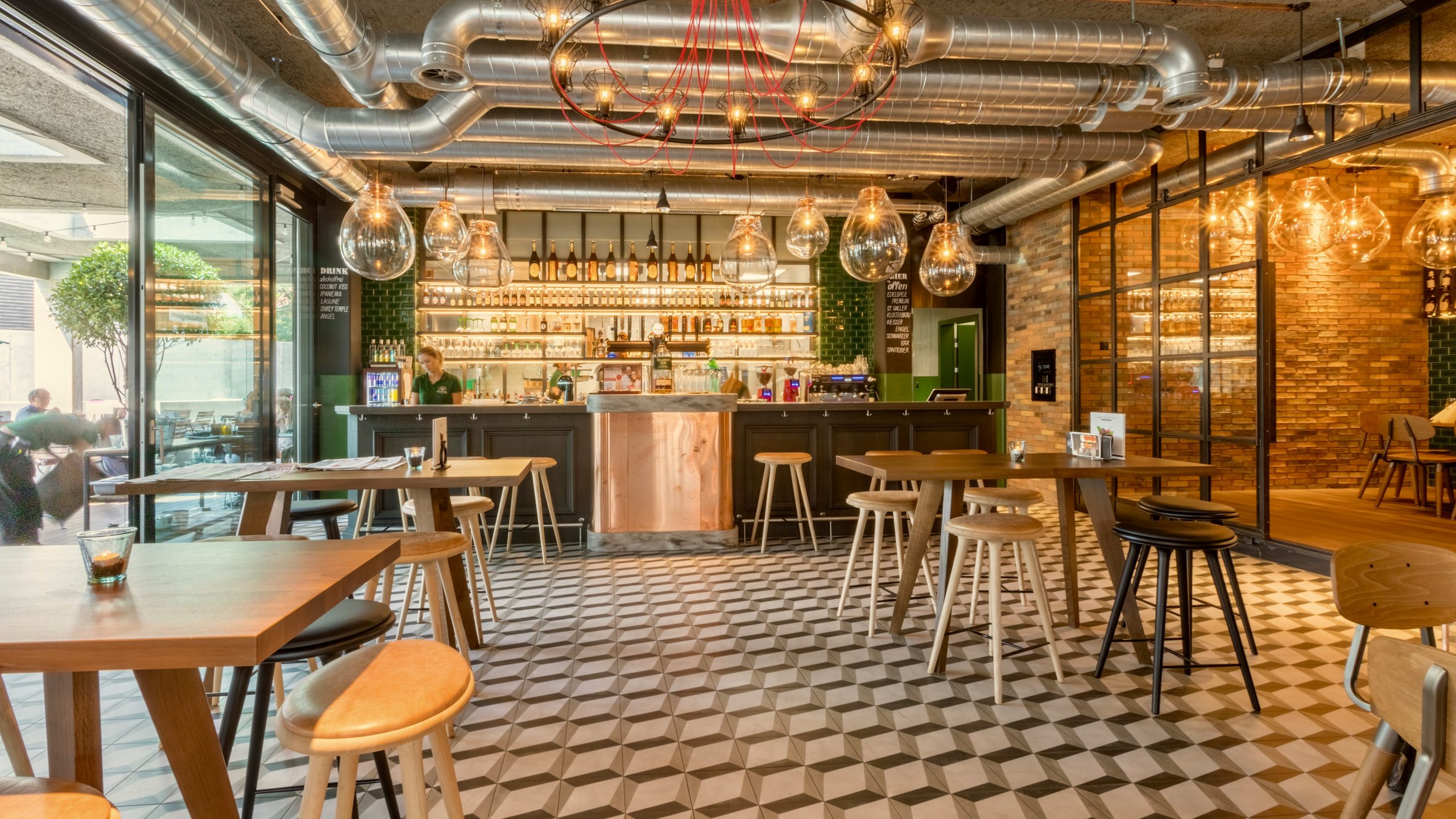Restaurant with geometric floor tiles, copper service counter and timber tables