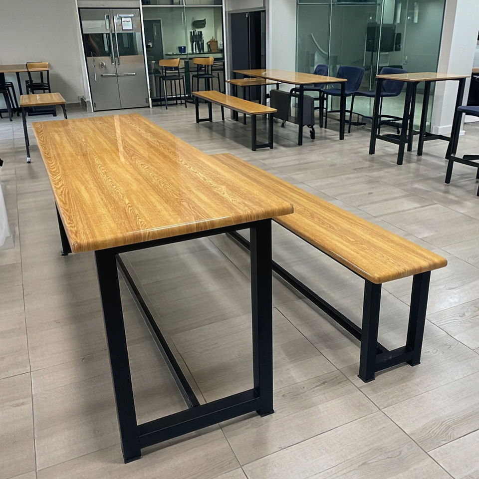 Bench and table sets installed in a staff canteen, with high tables and chairs alongside
