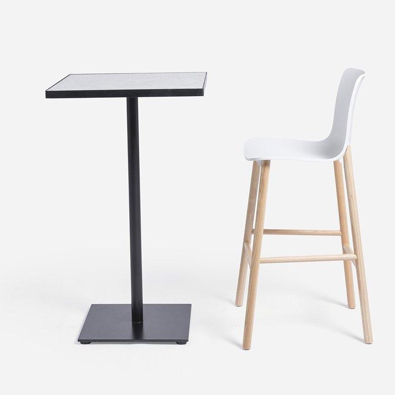 The table standing next to a counter-height stool to show the working height