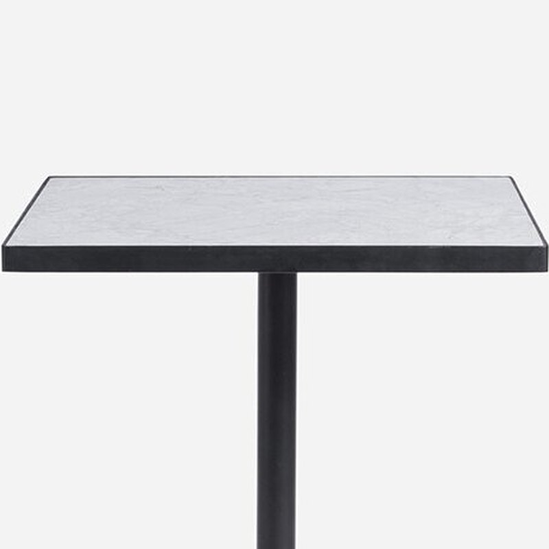 Close view of the tabletop edge: laminate core wrapped with a black edge band