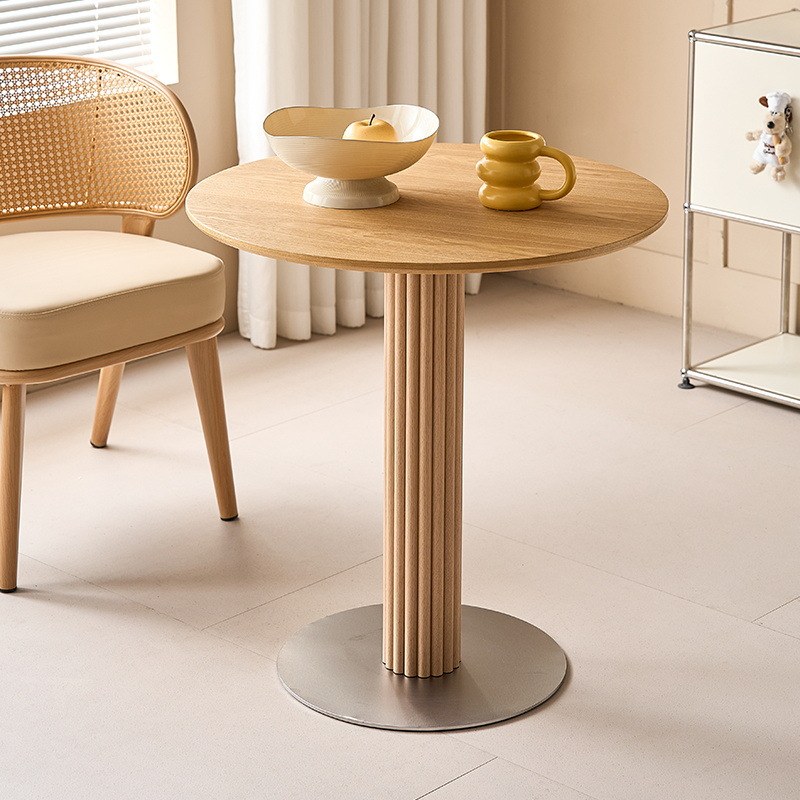 The same table in natural oak with a brushed steel disc base in a light dining room