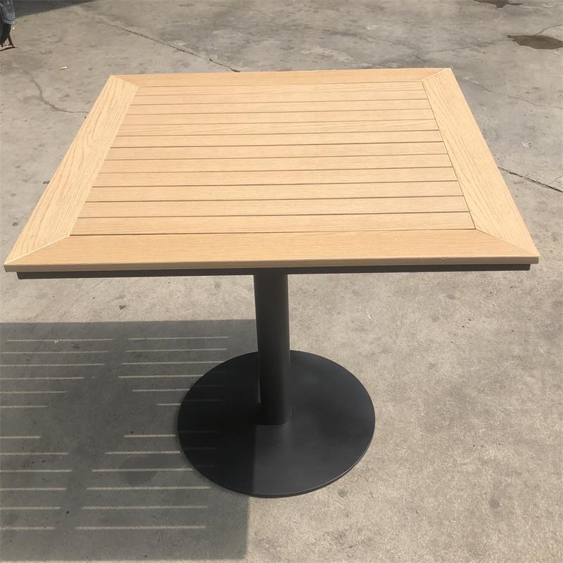 The table straight on, with the slat gaps casting a striped shadow on the floor